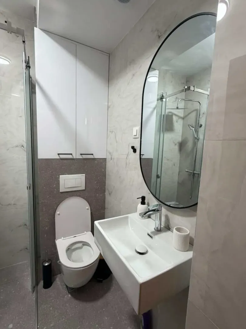 Moderno opremljeno kupatilo sa tuš kabinom, umivaonikom i wc šoljom.