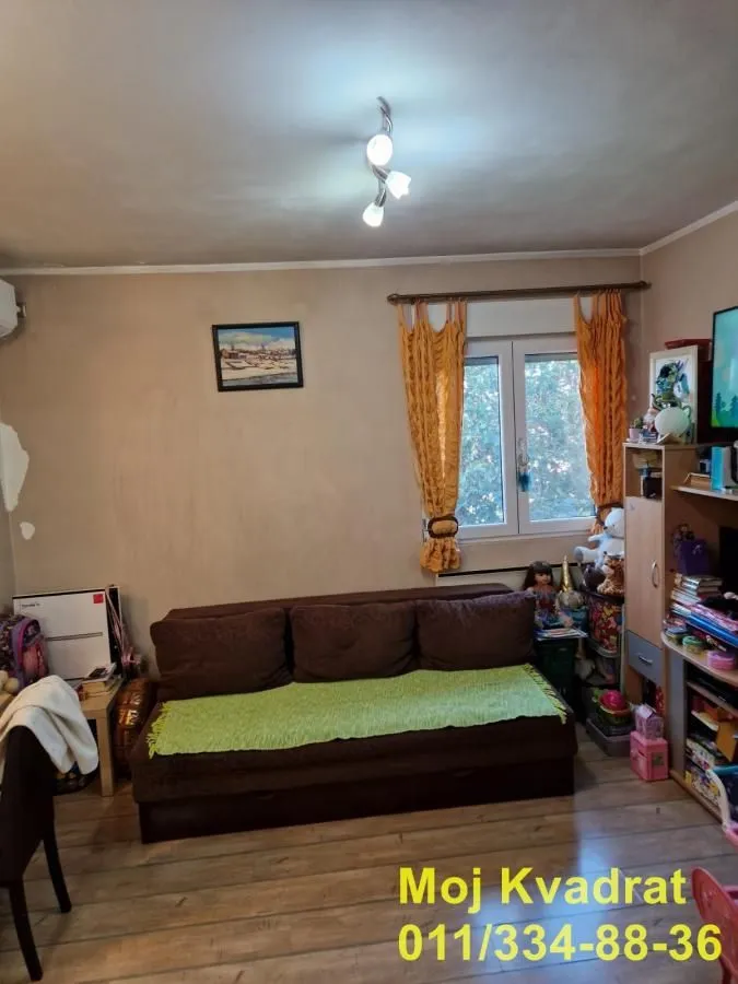 Dnevna soba sa garniturom za sedenje i prozorom.