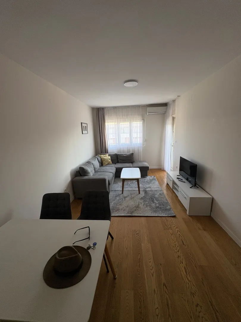 Spacious living room with a sofa set and a dining table in the foreground.