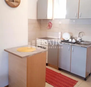 Smaller kitchen with cabinets and a dining area. - image 3