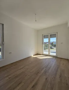 Prazna soba sa laminatom i balkonskim vratima. - image 4