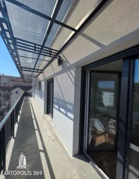 Long covered balcony with a metal railing and a view of the surroundings. - image 18