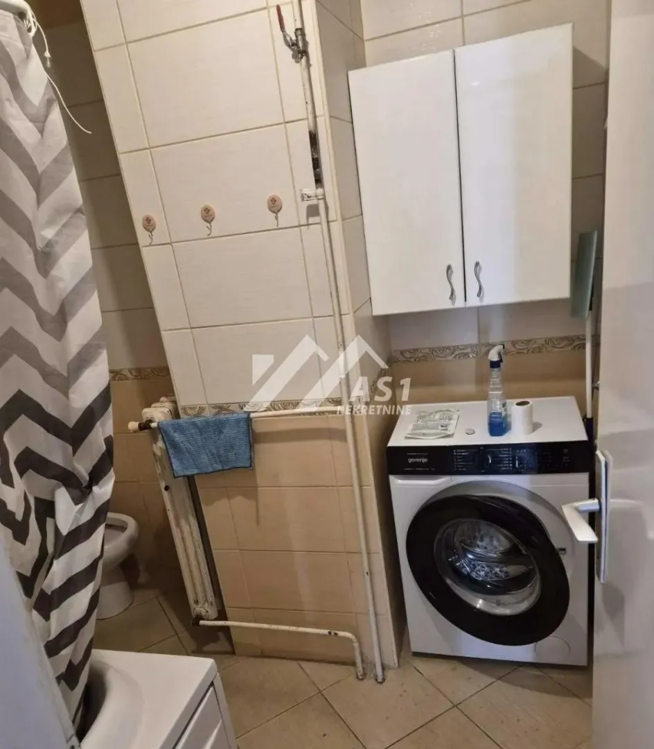 Kupatilo opremljeno sanitarijama, tuš kabinom i veš mašinom.