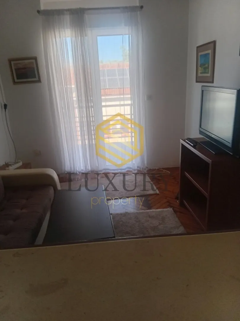 Living room with sofa, television, and access to the terrace.