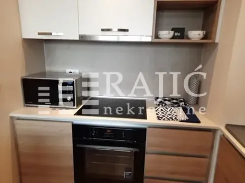 Small equipped kitchen with a built-in oven, hob, and microwave. - image 3