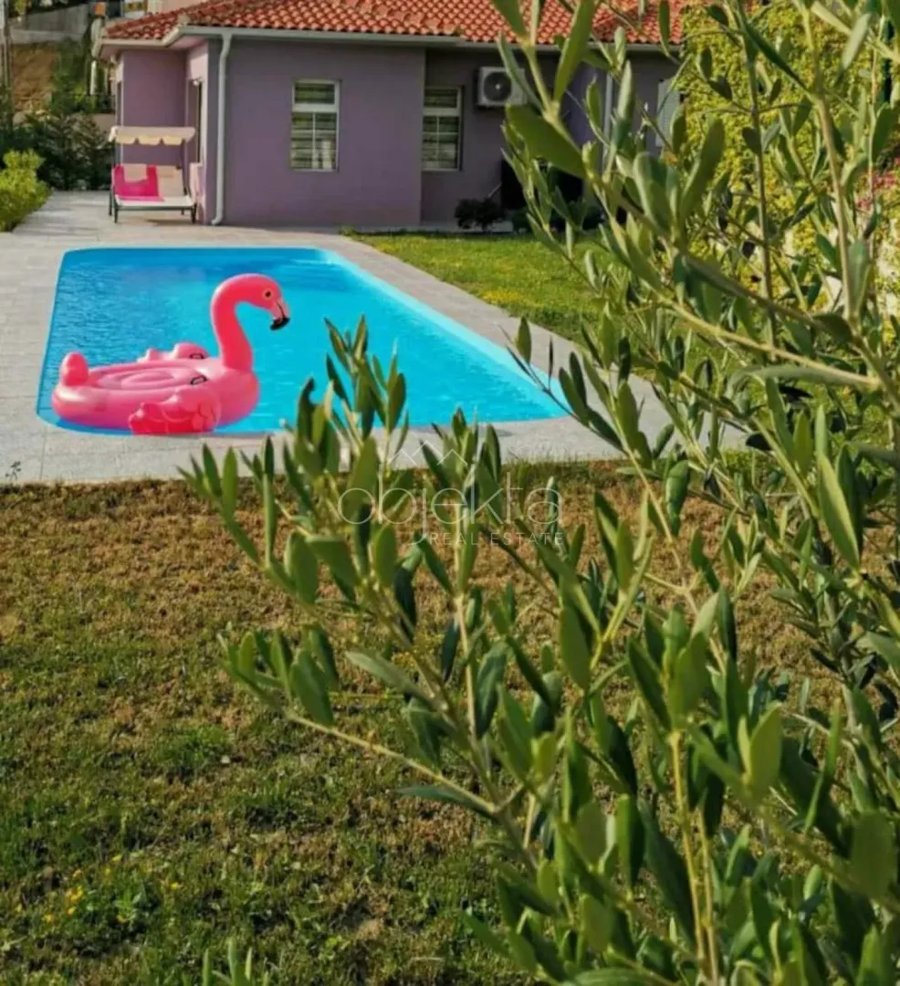 Yard of the house with a swimming pool and lawn.