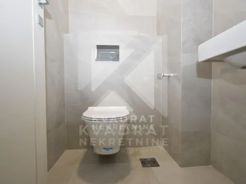 Modernly equipped bathroom with grey tiles and a wall-hung toilet. - image 13