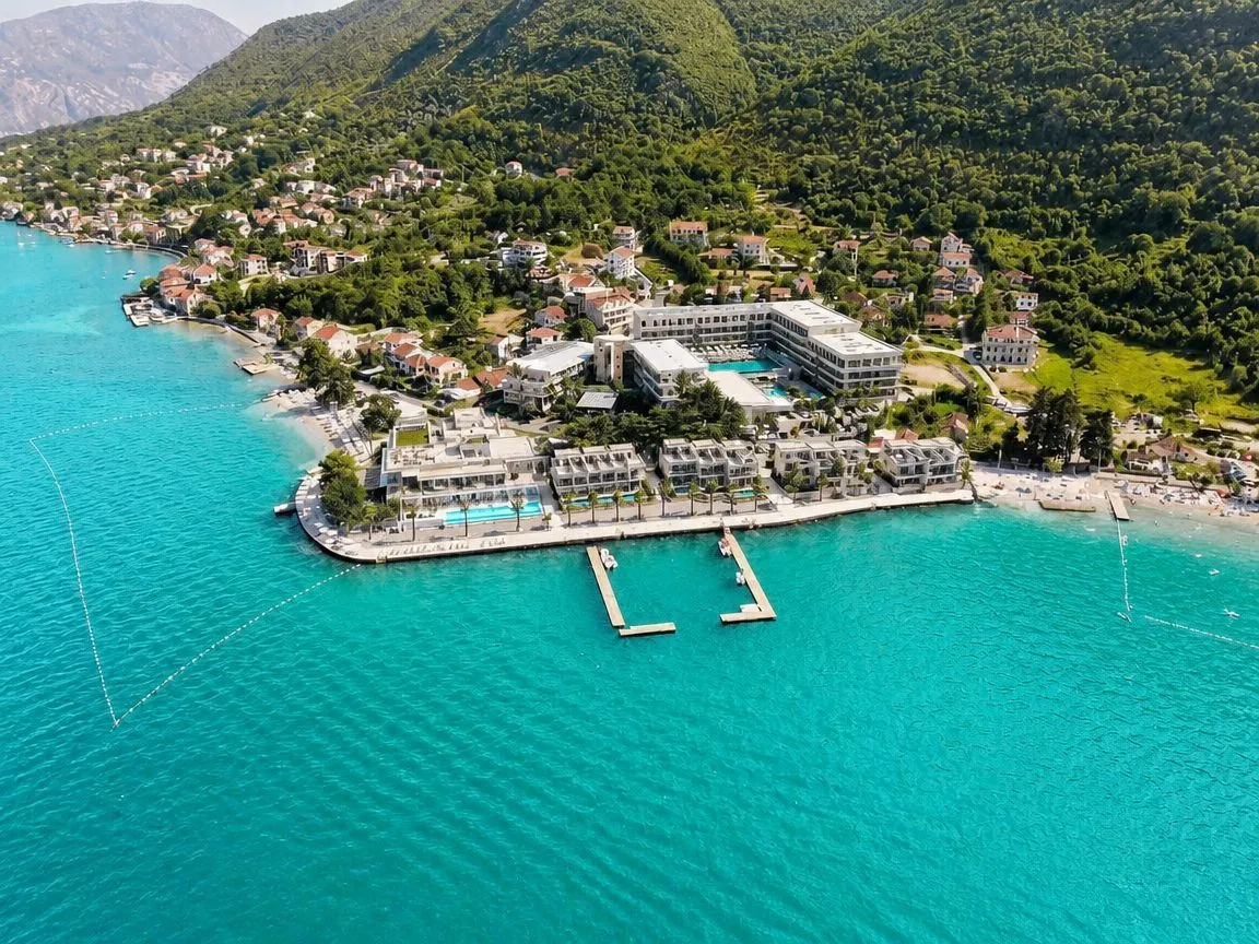 Pogled iz vazduha na hotelski kompleks sa obalom i pristaništem.