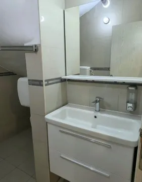 Smaller bathroom with a washbasin, mirror and neutral-toned tiles. - image 6