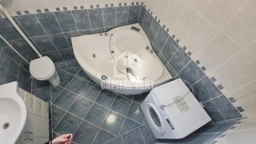 Kupatilo opremljeno ugaonom kadom, toaletom, umivaonikom i veš mašinom.