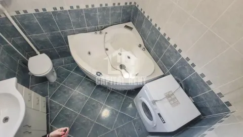 Kupatilo opremljeno ugaonom kadom, toaletom, umivaonikom i veš mašinom. - image 4