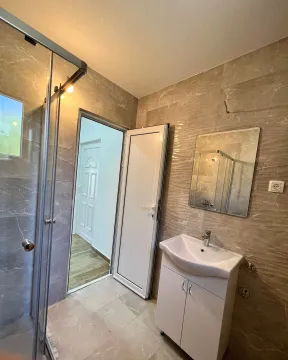 Bathroom with a shower cabin, washbasin, and mirror. - image 7