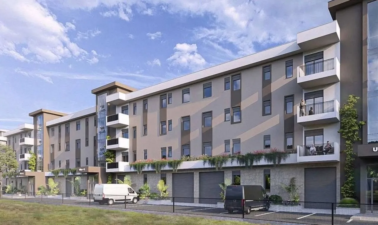 Spoljašnji izgled moderne stambene zgrade sa terasam i uređenim dvorištem.