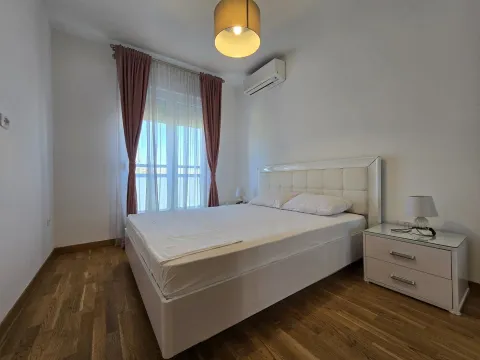 Svijetla spavaća soba sa bijelim bračnim krevetom i parketom. - image 10
