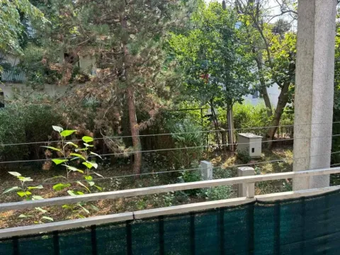 View from the balcony overlooking a green yard with trees. - image 6