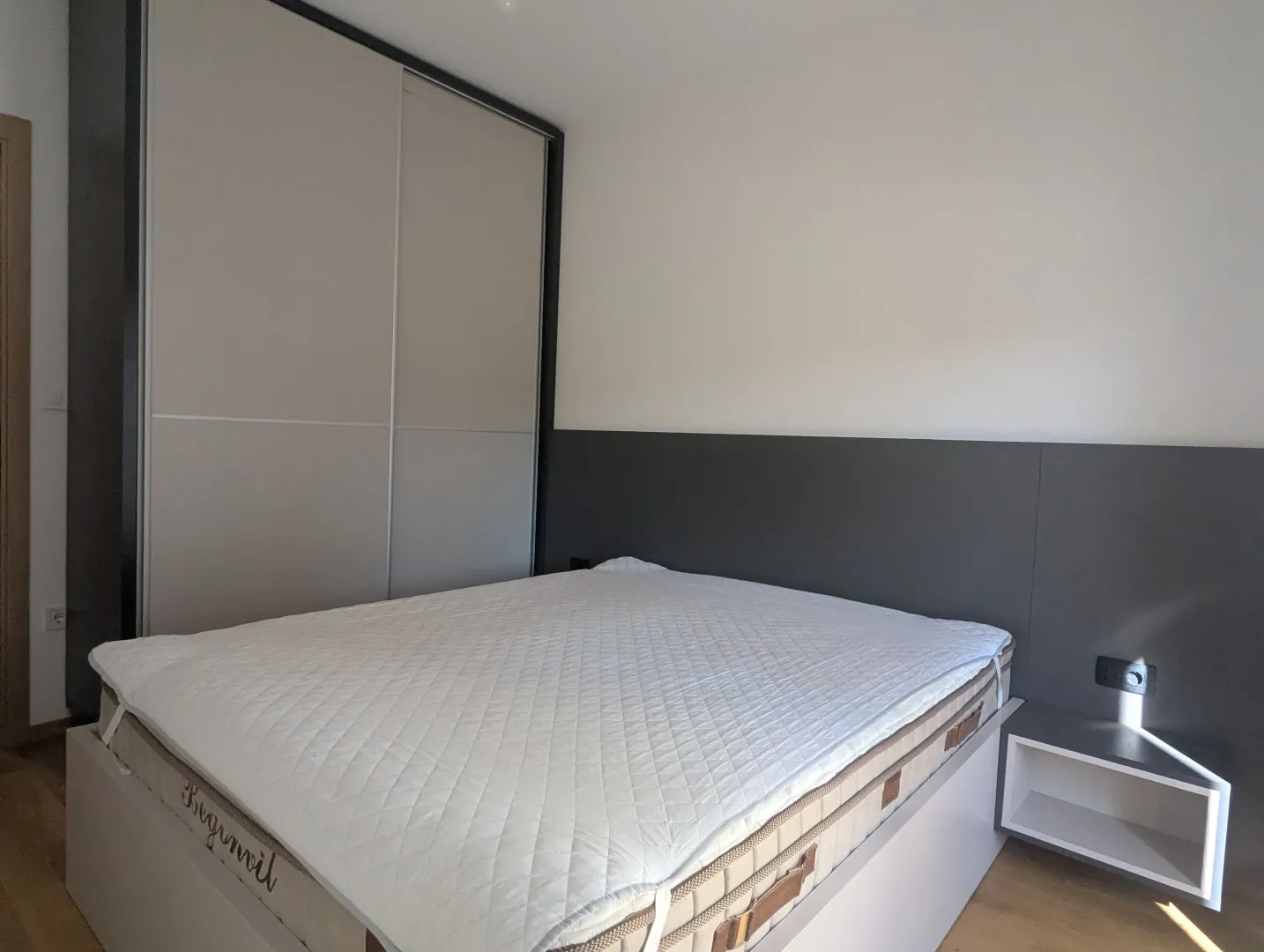 Modern bedroom with a double bed and a fitted wardrobe.
