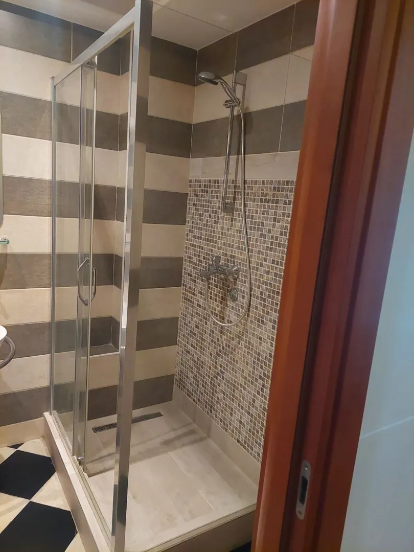 Pogled na moderno uređeno kupatilo sa tuš kabinom.