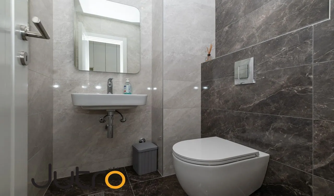 Moderne kupatilo sa umivaonikom, ogledalom i konzolnom wc šoljom.