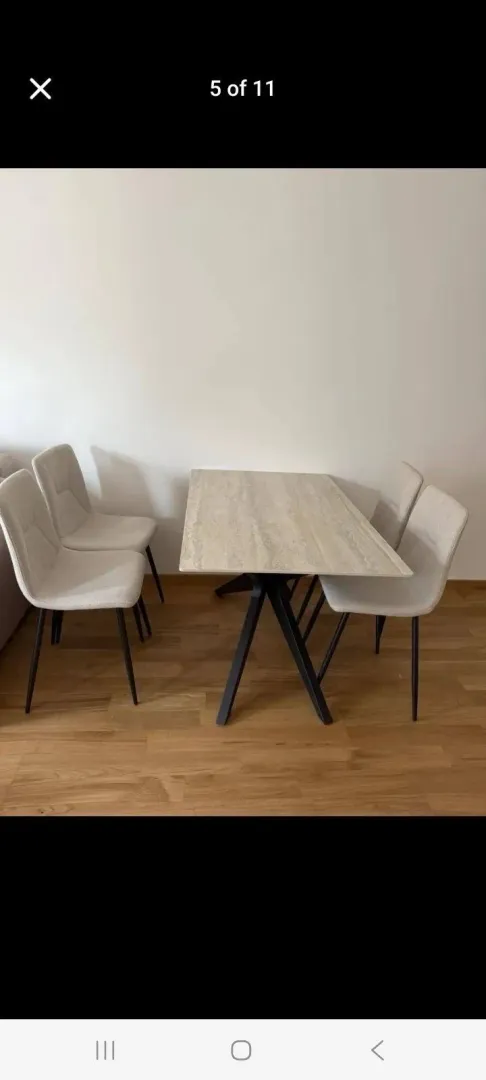 Trpezarijski sto sa četiri stolice u svijetloj prostoriji.