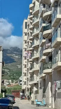 Pogled na spoljašnjost stambene zgrade sa terasam i planinskim pejzažom u pozadini. - image 7