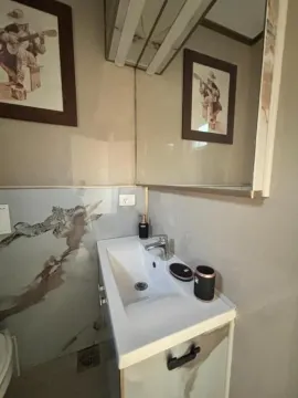 Manje kupatilo sa umivaonikom, ogledalom i zidnim ukrasima. - image 13