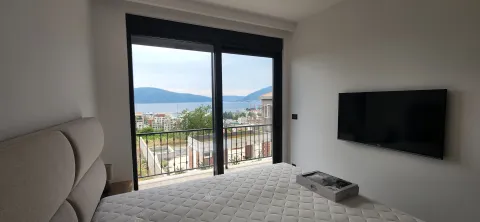 Moderna spavaća soba sa bračnim krevetom, televizorom i pogledom na more. - image 2