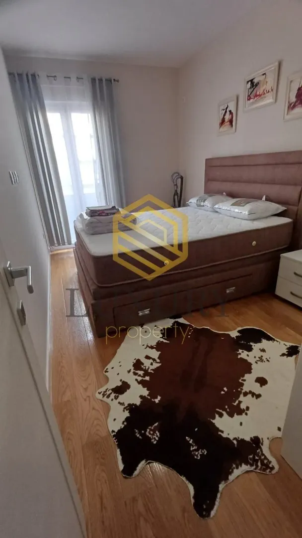 Bedroom with a double bed, hardwood flooring, and a decorative rug.