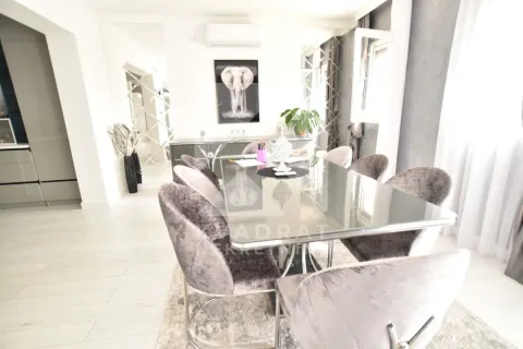Dining area with a large table and modern upholstered chairs. - image 8