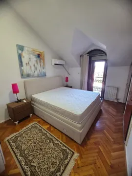 Furnished bedroom with a double bed and parquet flooring. - image 13