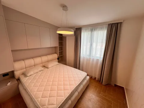 Modern bedroom with a double bed, built-in wardrobes, and a window with curtains. - image 7