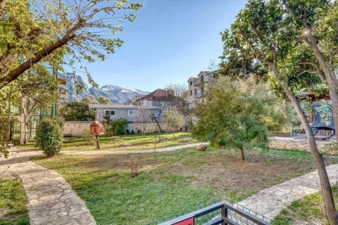 Zeleno dvorište sa stazom, drvećem i pogledom na planine u pozadini. - image 8