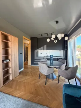 Dining area with a modern table and chairs, connected to the kitchen in the background. - image 2