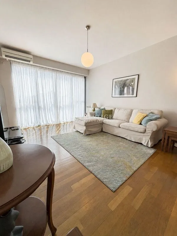 Living room with a sofa and hardwood floors.