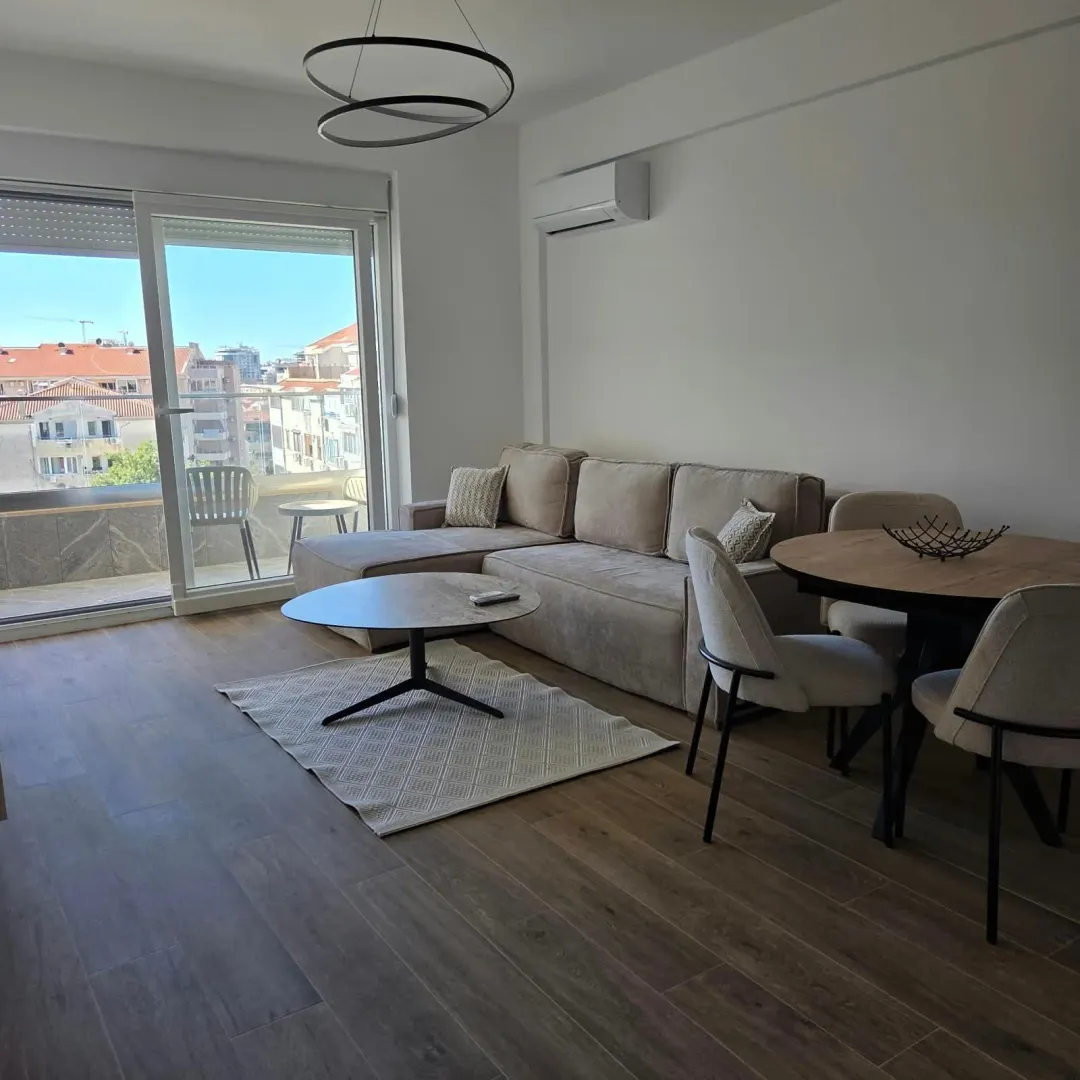Living room with sofa, dining table, and access to the terrace.