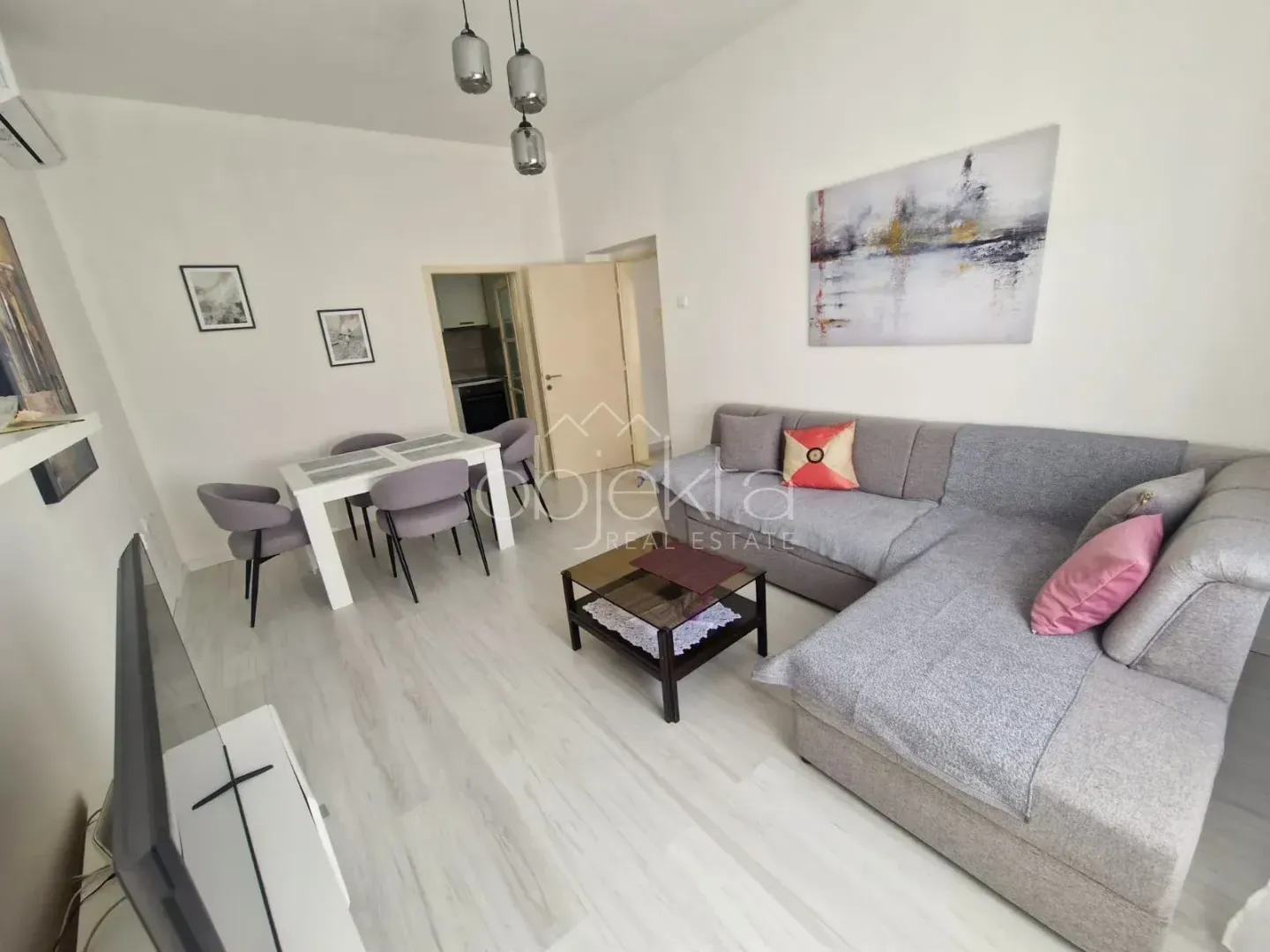 Living room with sofa, dining table, and television.
