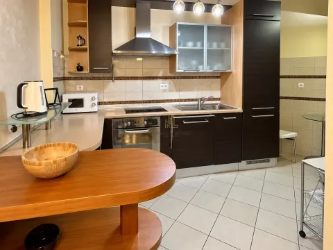 Modern kitchen with dark wood cabinetry, built-in appliances, and a dining table. - image 4