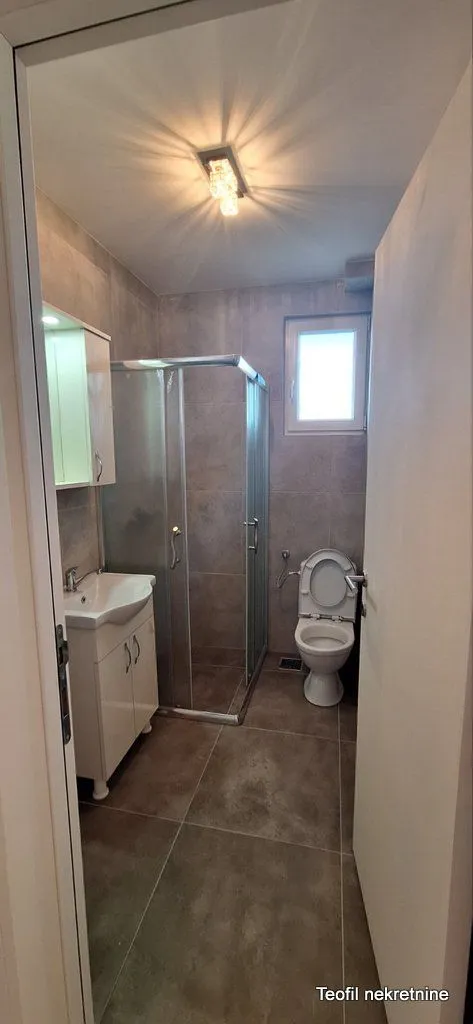Kupatilo sa tuš kabinom, umivaonikom i toaletom.
