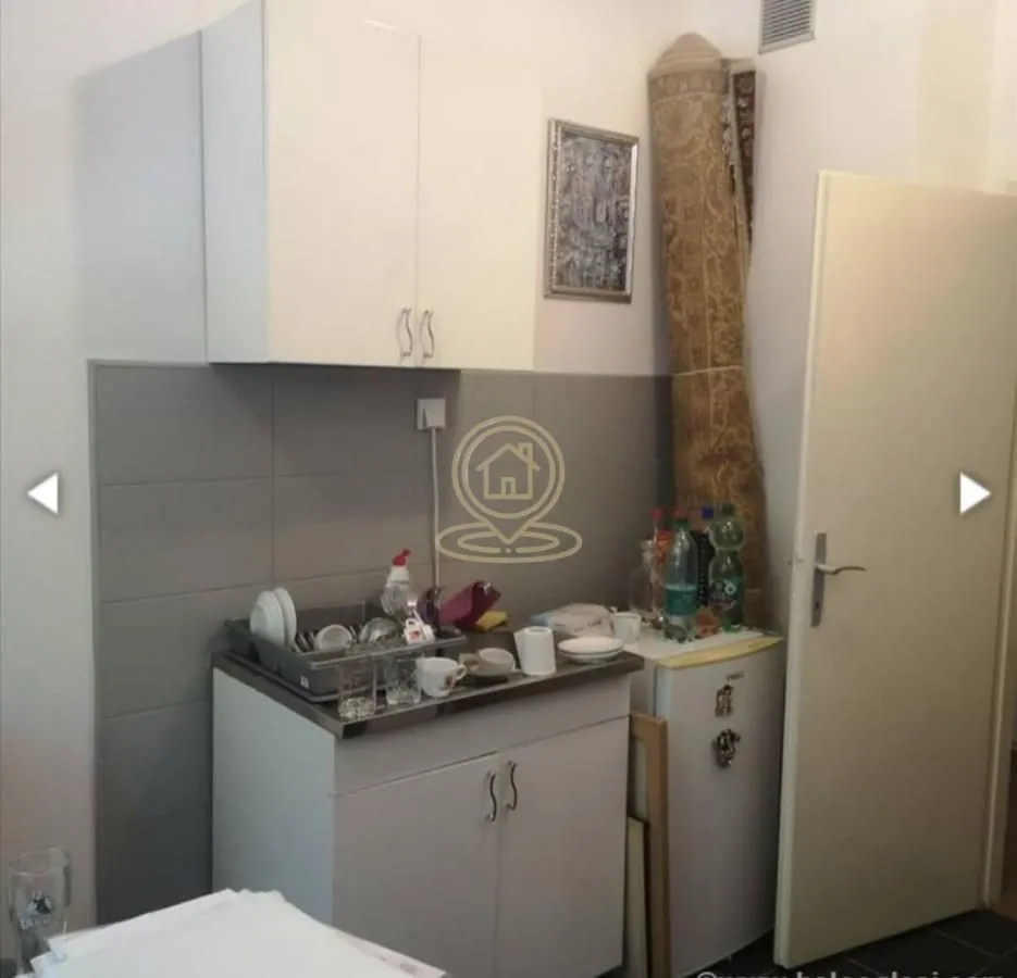 Small kitchen with a sink, cabinetry, and a refrigerator.