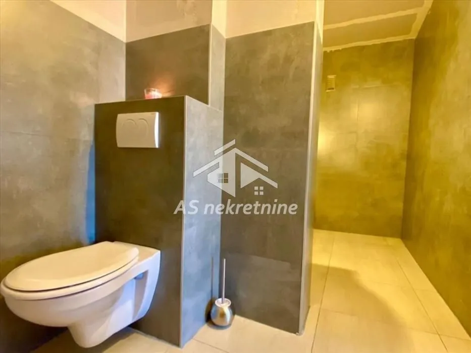 Tiled bathroom with a wall-hung toilet and concealed cistern.