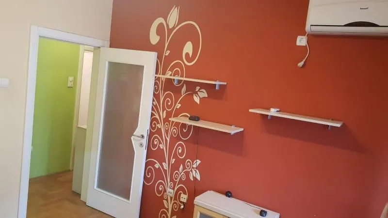 Dnevna soba sa crvenim zidom i ukrasnim nalepnicama.