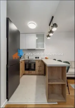 Modern kitchen with wooden cabinetry, a black refrigerator, and a bar counter. - image 4
