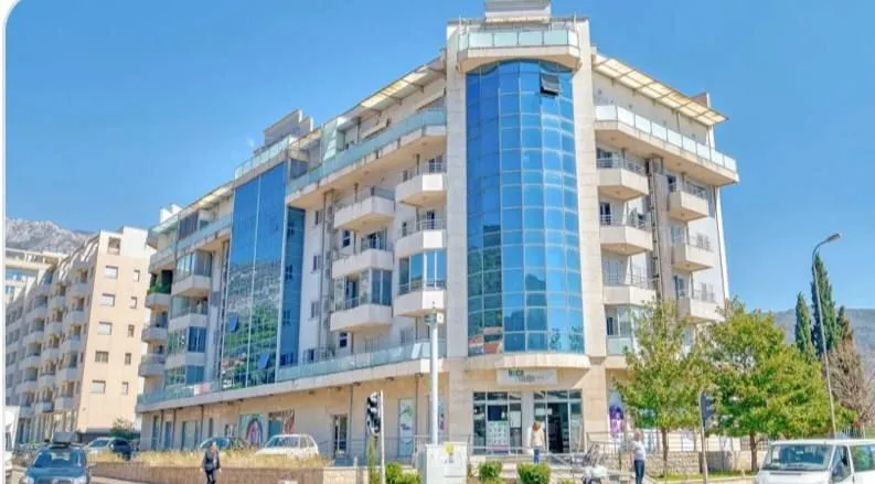 Exterior of a multi-family residential building with glass facade elements and balconies.