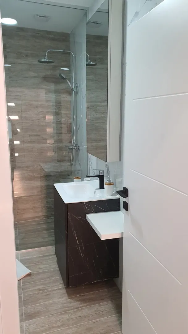 View of a modern bathroom with a vanity and a walk-in shower.