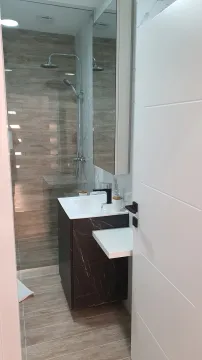 View of a modern bathroom with a vanity and a walk-in shower. - image 8