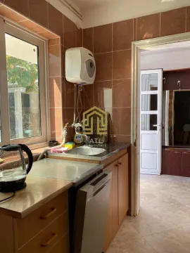 Small kitchen with a sink, water heater, and tiled walls. - image 4