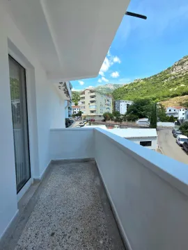 Bijeli balkon sa pogledom na okolne zgrade i planine. - image 7