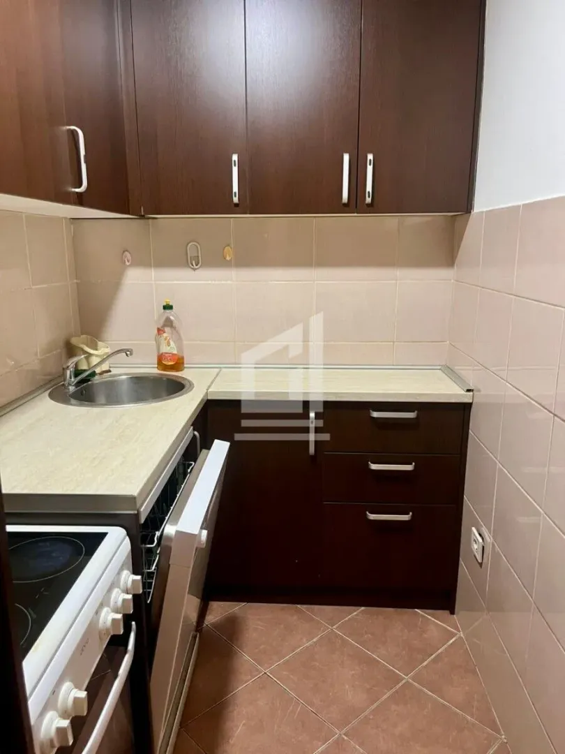 Small kitchen with dark wooden cabinets and a sink.