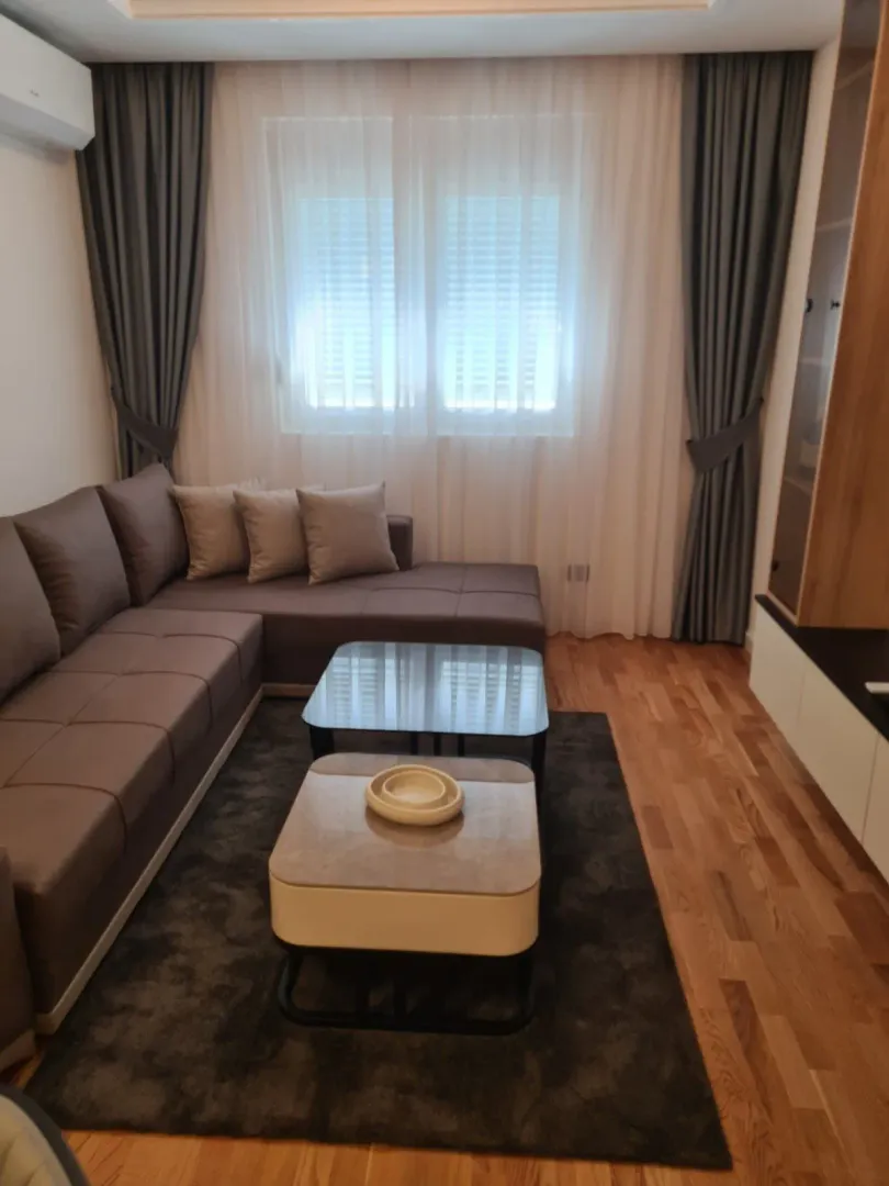 Bright living room with a corner sofa and coffee tables.