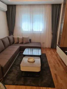 Bright living room with a corner sofa and coffee tables. - image 3