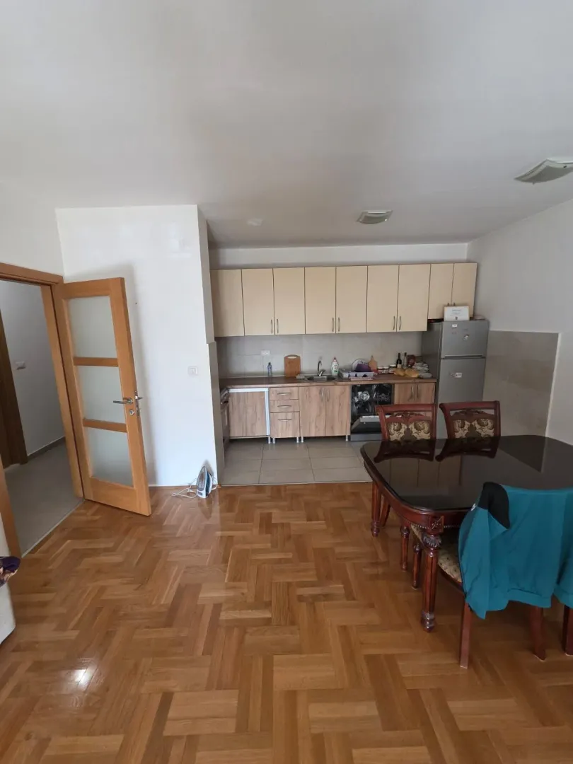 Manja kuhinja sa trpezarijom i drvenim podom.
